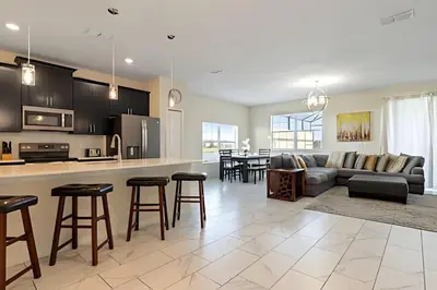 a kitchen and living room with a couch and a table at Casa 5Q c/ Piscina – 10min da Disney + Resort in Kissimmee