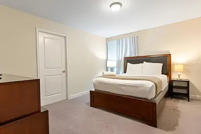 a bedroom with a bed and a dresser and a door at Casa 5Q c/ Piscina – 10min da Disney + Resort in Kissimmee