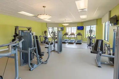 a gym with treadmills and elliptical machines at Casa 5Q c/ Piscina – 10min da Disney + Resort in Kissimmee