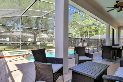 a patio with chairs and a table and a pool at Villa 6Q Moderna c/ Piscina Priv. e Resort in Orlando