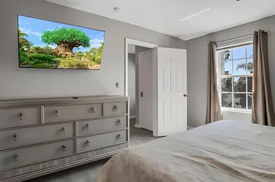 a bedroom with a dresser and a tv on the wall at Villa 6Q Moderna c/ Piscina Priv. e Resort in Orlando