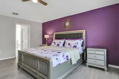 a purple bedroom with a bed and a purple wall at Villa 6Q Moderna c/ Piscina Priv. e Resort in Orlando