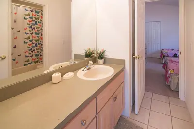 a bathroom with a sink and a mirror at Cumbrian Retreat in Kissimmee