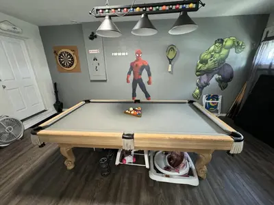 a pool table in a room with a spider man wall at Villa Crayson in Kissimmee