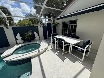 a patio with a table and a swimming pool at Villa Crayson in Kissimmee