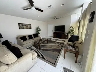 a living room with couches and a flat screen tv at Villa Crayson in Kissimmee