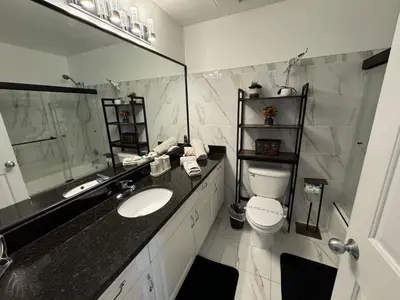 a bathroom with a sink and a toilet and a mirror at Villa Crayson in Kissimmee