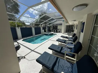 a room with chairs and a swimming pool at Villa Crayson in Kissimmee