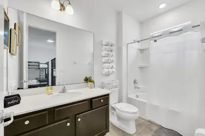 a bathroom with a sink and a toilet and a mirror at Spacious Dreamscape 12rooms 11 bathrooms 25 people Wifi in Kissimmee