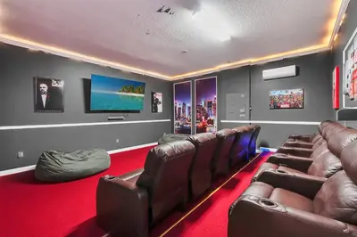 a movie room with leather chairs and a flat screen tv at Spacious Dreamscape 12rooms 11 bathrooms 25 people Wifi in Kissimmee