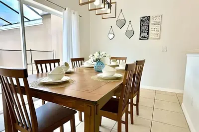 a dining room with a wooden table and chairs at Casa aconchegante 4Q/3B Piscina Priv. in Kissimmee