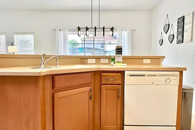 a kitchen with a sink and a white dishwasher at Casa aconchegante 4Q/3B Piscina Priv. in Kissimmee