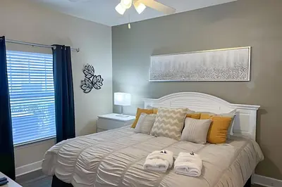 a bedroom with a white bed with two towels on it at Casa 4Q perto da Disney c/ Resort e Padaria in Kissimmee