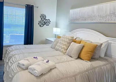 a white bed with two pillows on it in a bedroom at Casa 4Q perto da Disney c/ Resort e Padaria in Kissimmee