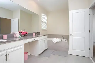 a white bathroom with a sink and a mirror at Villa 5 Quartos com Piscina no Storey Lake in Kissimmee