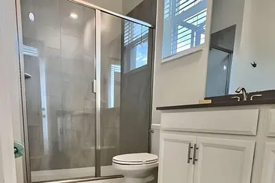 a bathroom with a toilet and a glass shower at Villa 5 Quartos com Piscina no Storey Lake in Kissimmee