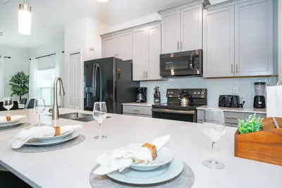 a kitchen with white cabinets and a white counter top at Epic Elegance Home Resort Amenities Disney10 miles in Kissimmee