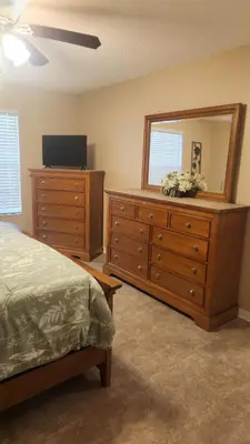 a bedroom with a bed and a dresser with a mirror at Disney Area Condo at Laguna Bay Villas! in Kissimmee