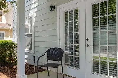 a black chair sitting on the front porch of a house at Casa 4Q c/ Piscina e Clubhouse — 10min da Disney in Kissimmee