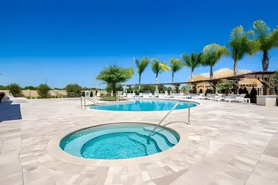 a pool in a courtyard with palm trees at Casa 4Q c/ Piscina e Clubhouse — 10min da Disney in Kissimmee