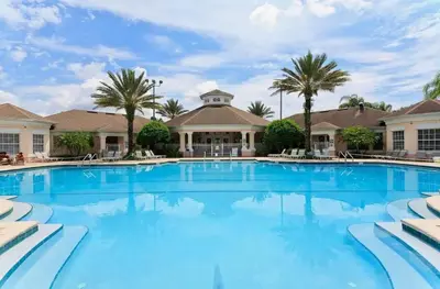 a large swimming pool with palm trees and a building at Windsor Palms Oasis Harry Potter Mickey Pool Spa in Kissimmee