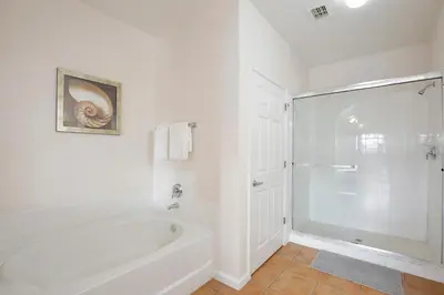 a white bathroom with a tub and a shower at New in the market apt with big terrace! in Orlando