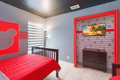 a bedroom with a red bed and a wooden wall at Fascinating Private Pool And Game-Room, Near Disney!! in Kissimmee
