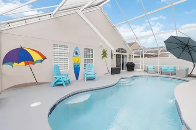 a swimming pool with chairs and an umbrella at Fascinating Private Pool And Game-Room, Near Disney!! in Kissimmee