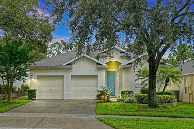 a white house with a garage at Splash, Play, with a Disney Stay in Orlando