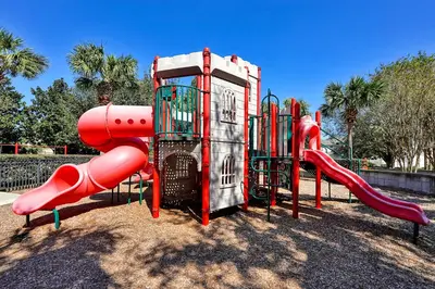 a playground with a red slide in a park at Splash, Play, with a Disney Stay in Orlando