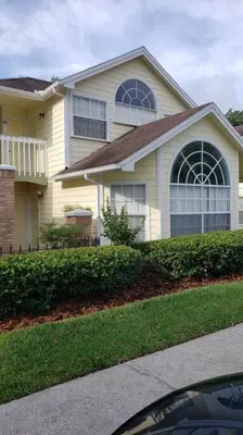 a white house with windows and a driveway at Laguna Bay Villas - Disney Area Condo in Kissimmee