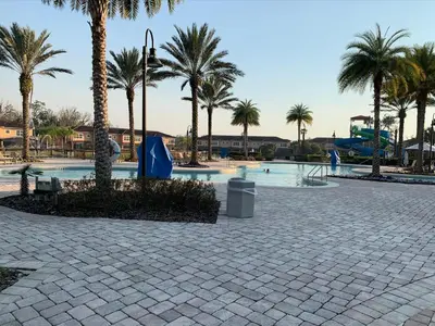 a swimming pool with palm trees in a resort at Four Bedroom Townhouse in Regal Oaks at Old Town in Orlando
