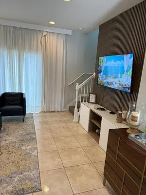 a living room with a flat screen tv on a wall at 2BR Townhouse Near Disney in Kissimmee