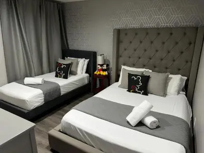a bedroom with two beds with white sheets and a headboard at 2BR Townhouse Near Disney in Kissimmee