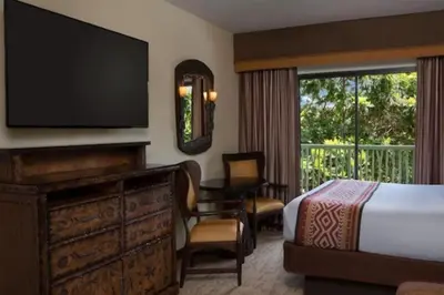 a hotel room with a bed and a large window at Disney's Animal Kingdom Villas - Jambo House in Orlando