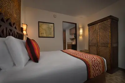 a bedroom with a bed with pillows and a cabinet at Disney's Animal Kingdom Villas - Jambo House in Orlando