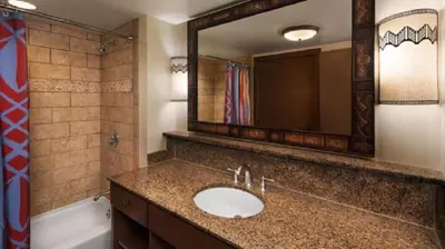 a bathroom with a sink and a mirror and a tub at Disney's Animal Kingdom Villas - Jambo House in Orlando