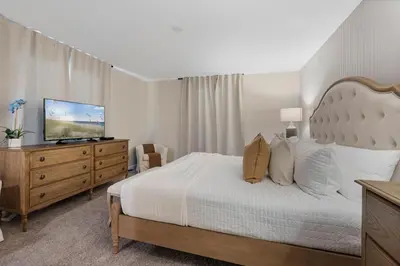 a bedroom with a bed and a dresser with a television at Amazing 5Bdrms At Storey Lake in Kissimmee
