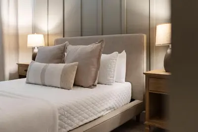 a white bed with white pillows and two lamps at Amazing 5Bdrms At Storey Lake in Kissimmee