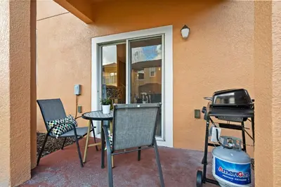 a patio with a table and chairs and a grill at Sweet 3 bedroom Townhome 2407 in Orlando