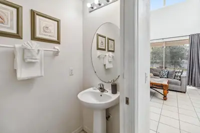 a white bathroom with a sink and a mirror at 765 Beautiful Vacation Home With Private Pool, And Much More!! in Kissimmee