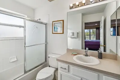 a bathroom with a toilet and a sink and a mirror at 765 Beautiful Vacation Home With Private Pool, And Much More!! in Kissimmee