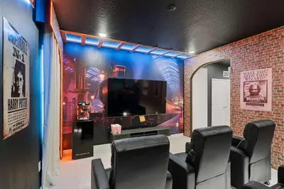 a room with chairs and a large screen tv at 5911 Luxury 10BD Family Home For an Unforgettable Vacation in Orlando