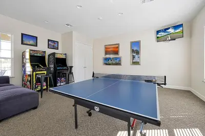 a living room with a ping pong table and video games at Family-Friendly home w/ Pool & Resort Perks Near Disney in Orlando