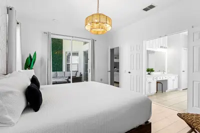 a bedroom with a white bed and a chandelier at Disney THEMED HOME, PRIVATE HEATED POOL, COMMUNITY WATERPARK in Orlando