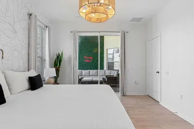 a white bedroom with a white bed and a chandelier at Disney THEMED HOME, PRIVATE HEATED POOL, COMMUNITY WATERPARK in Orlando
