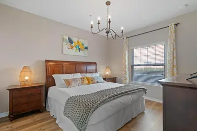 a bedroom with a large bed and a chandelier at Themed Villa, Great Location with proximity to Disney in Kissimmee