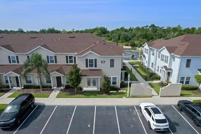 a parking lot with cars parked in front of houses at Themed Villa, Great Location with proximity to Disney in Kissimmee