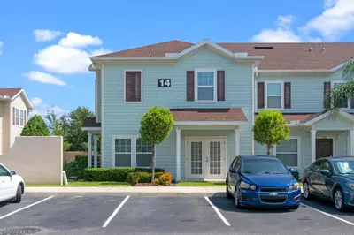 a blue house with two cars parked in a parking lot at Luxury Design with close proximity to DISNEY in Kissimmee