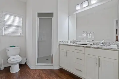a bathroom with a toilet and a sink and a mirror at Luxury Design with close proximity to DISNEY in Kissimmee